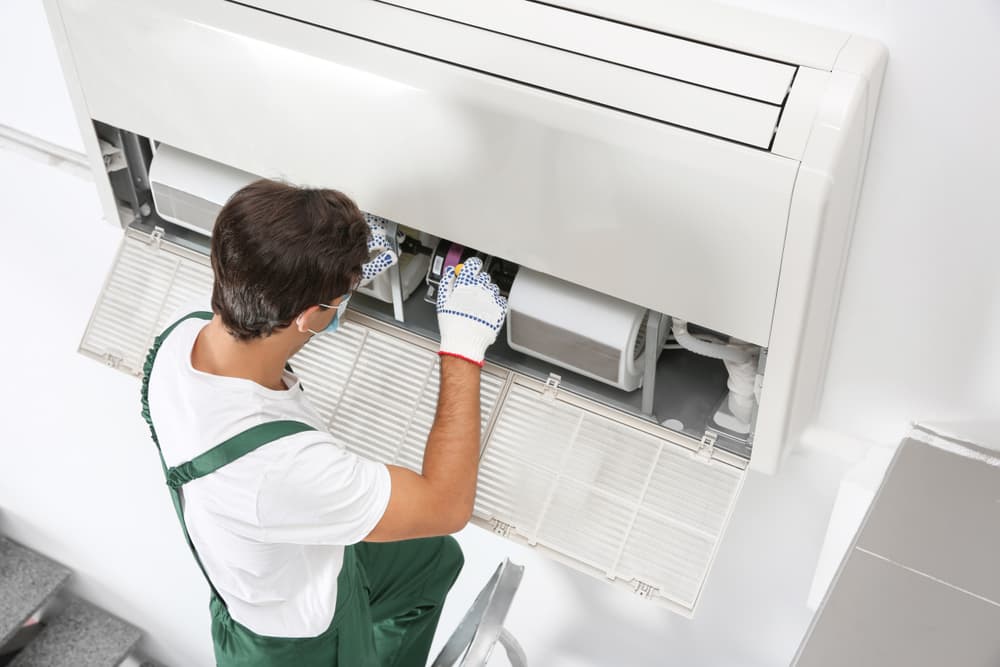 Technician fixing air conditioner — Air Conditioning Solutions In Gold Coast, NSW