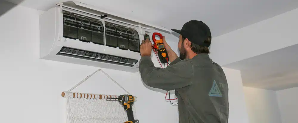 Man Doing Maintenance Checks on Air Conditioner