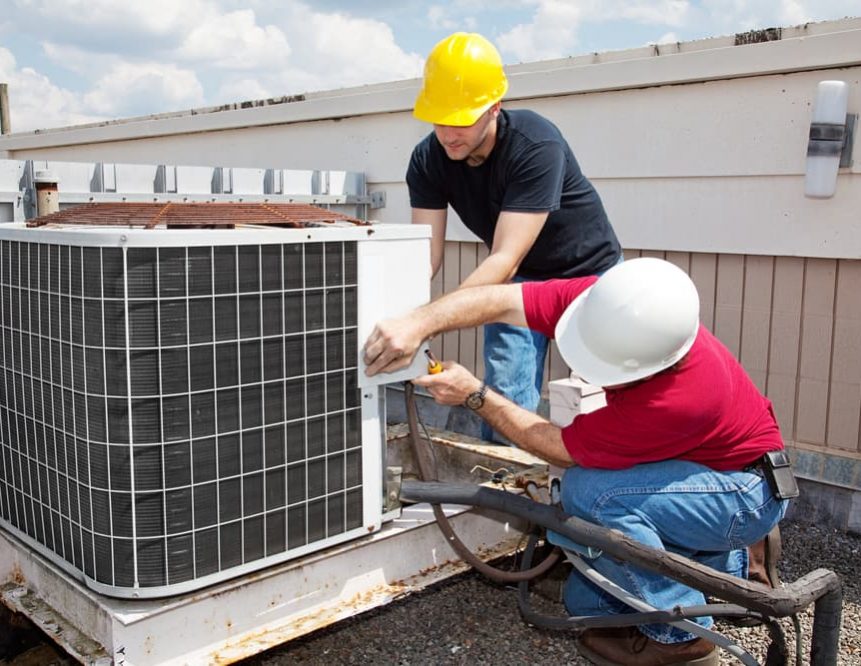 Two air conditioner specialist fixing air conditioner — Air Conditioning Solutions In Tweed Heads, NSW