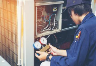 Technician checking air conditioner freon level — Air Conditioning Solutions In Tweed Heads, NSW