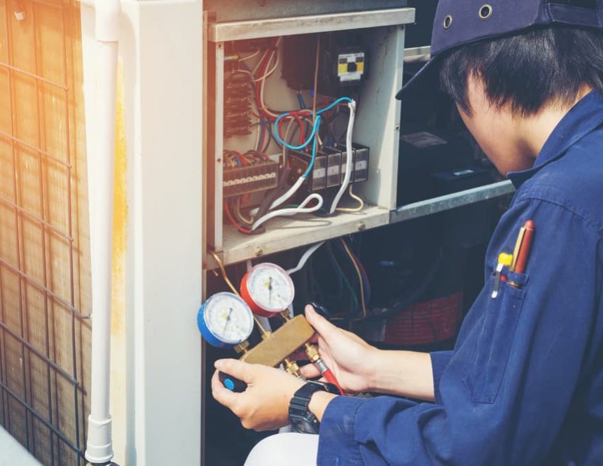 Technician checking air conditioner freon level — Air Conditioning Solutions In Tweed Heads, NSW