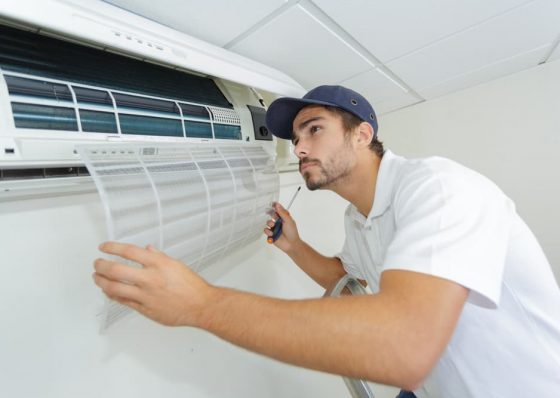 Technician checking air conditioner — Air Conditioning Solutions In Tweed Heads, NSW